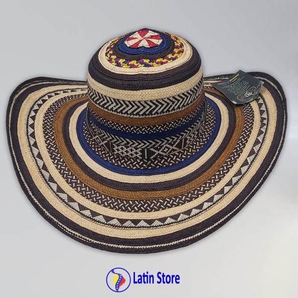 Este Sombrero Vueltiao premium es mucho más que un accesorio; es una pieza de colección que encarna la rica herencia cultural de la nación. Tejido a mano con la técnica ancestral Zenú en auténtica caña flecha, este diseño exclusivo presenta una sofisticada paleta de azul marino, beige y marrón, resaltada por un vibrante remate tricolor en la copa con los colores de la bandera de Colombia. Excelencia Artesanal: Cada sombrero es una obra de arte única, fruto de horas de meticuloso trabajo por maestros artesanos. Calidad y Lujo: El tejido fino y denso asegura una flexibilidad, durabilidad y suavidad inigualables, sintiéndose ligero y cómodo. Símbolo de Identidad: El distintivo patrón geométrico y el detalle tricolor lo convierten en una declaración de orgullo y estilo auténtico. Protección Elegante: Su ala ancha te brinda una excelente sombra, manteniéndote fresca y sofisticada en cualquier ocasión al aire libre. Ideal para: Amantes de la artesanía de lujo, coleccionistas y quienes buscan un accesorio que grite pasión por Colombia con elegancia. ¡Añade esta joya del arte colombiano a tu vida y hazte con tu Sombrero Vueltiao tricolor hoy en LatinStore!